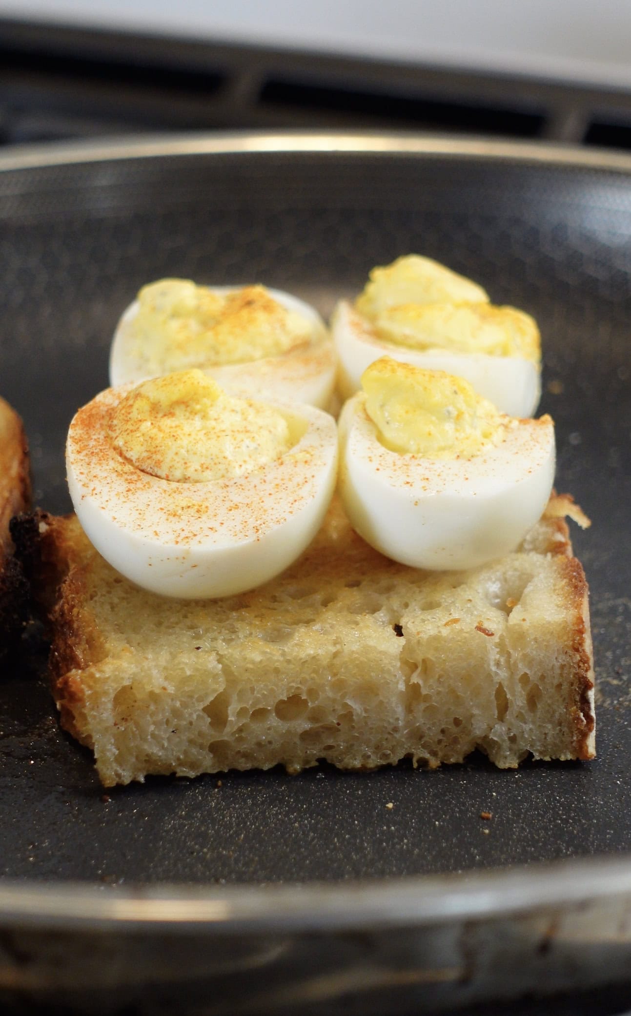 Deviled eggs sitting on toast.